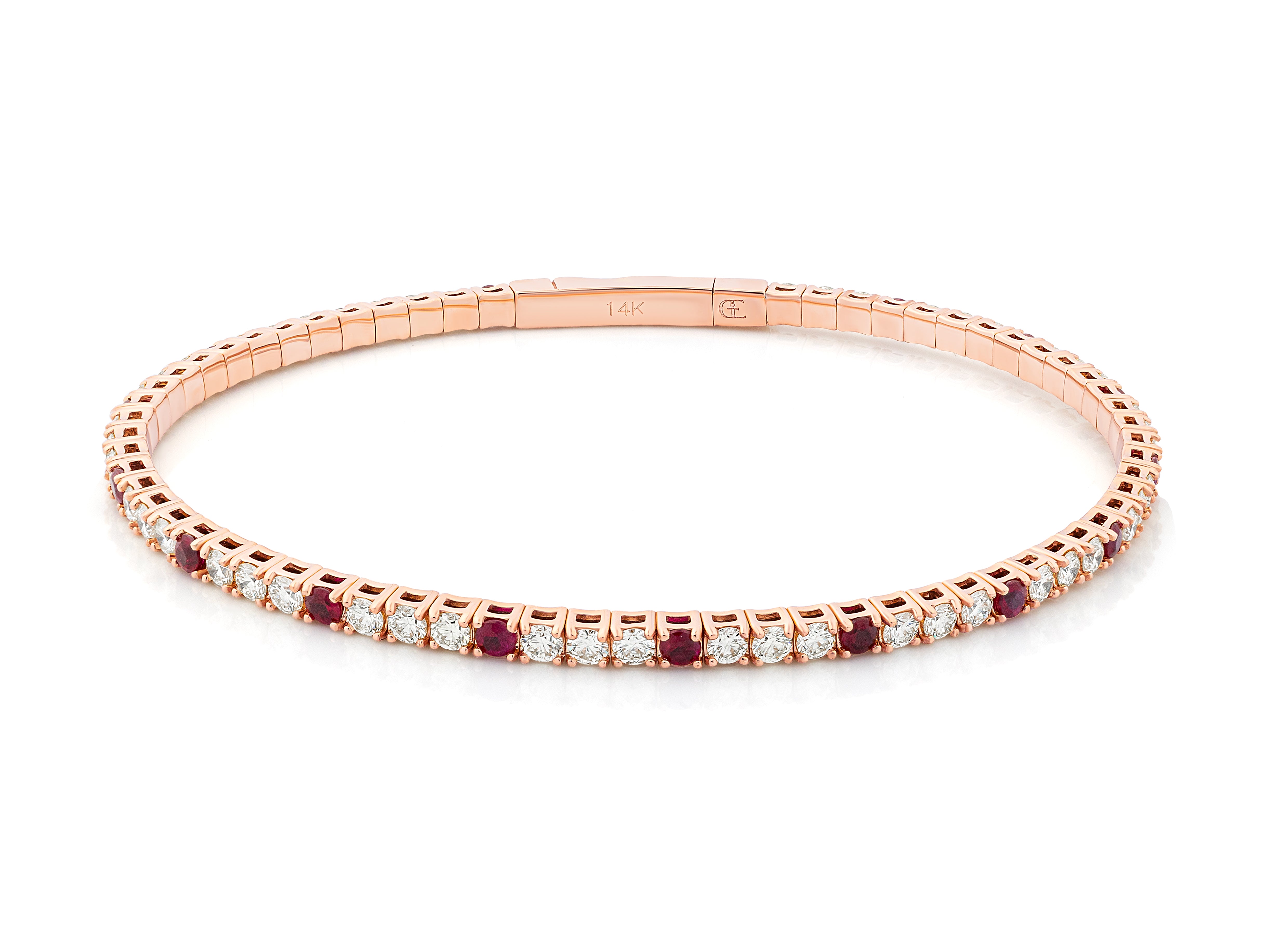 A rose gold flexible bangle bracelet with diamond and ruby accents