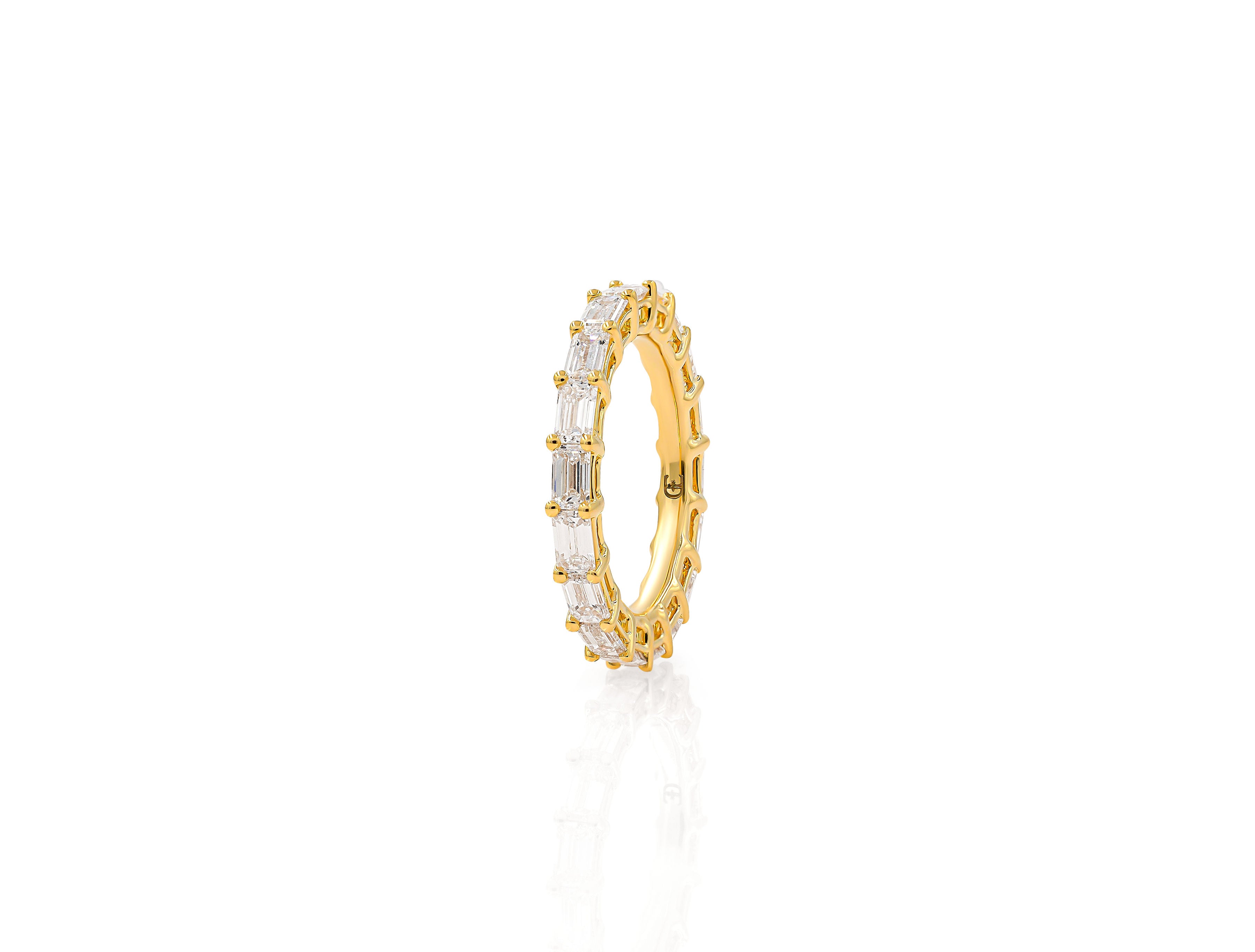 A single emerald cut diamond ring with smaller surrounding stones, set in a gold band.