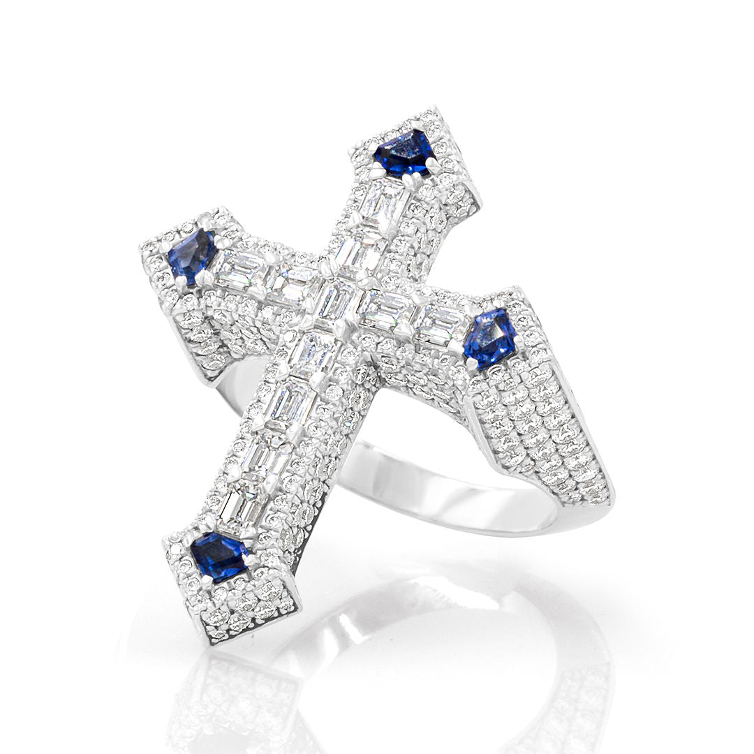 A diamond and sapphire cross ring with multiple blue sapphire stones and clear diamond stones set in white gold.