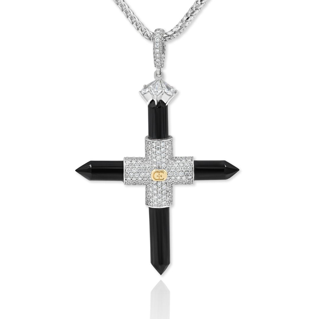 A white gold cross pendant with black accents and embedded with diamonds, suspended from a chain.