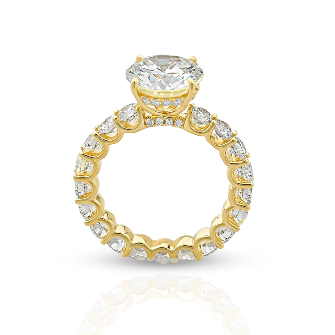 A gold eternity ring with multiple inset diamonds around the band, showcasing a luxurious and sparkling design.