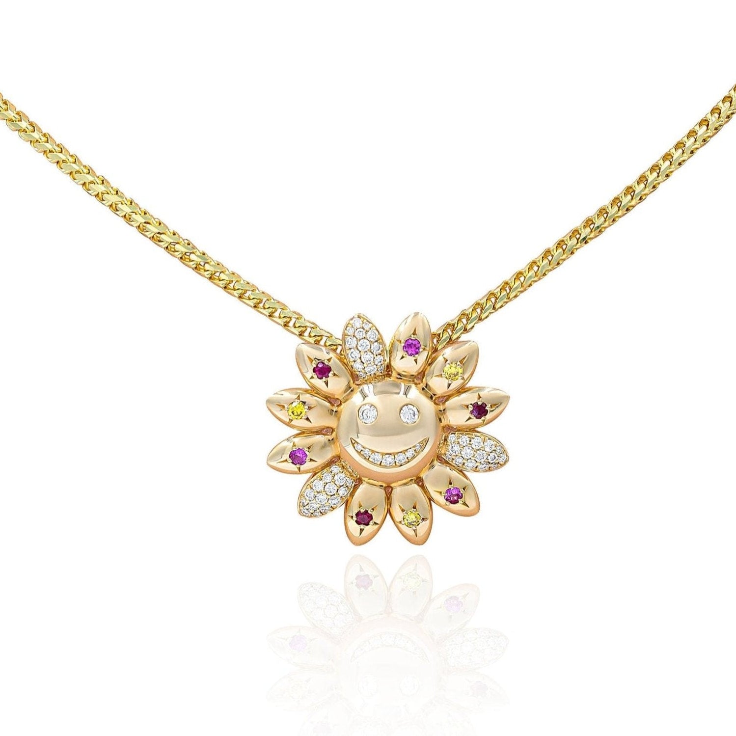 A gold necklace with a sunflower-shaped pendant featuring a smiley face, with a mix of white, pink, red, and yellow stones arranged in a floral pattern.