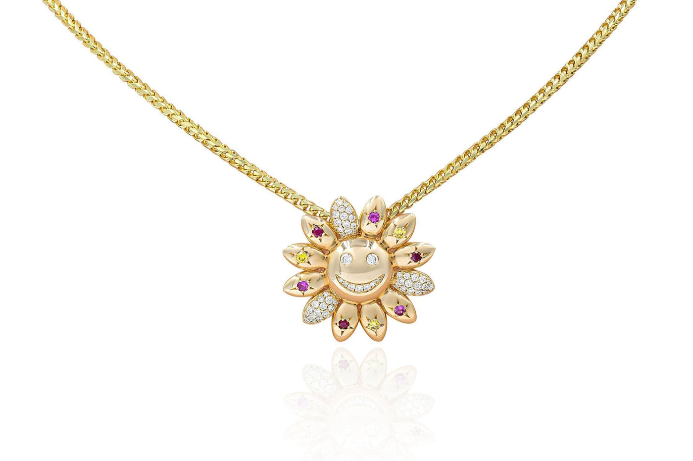 A gold necklace with a sunflower-shaped pendant featuring a smiley face, with a mix of white, pink, red, and yellow stones arranged in a floral pattern.