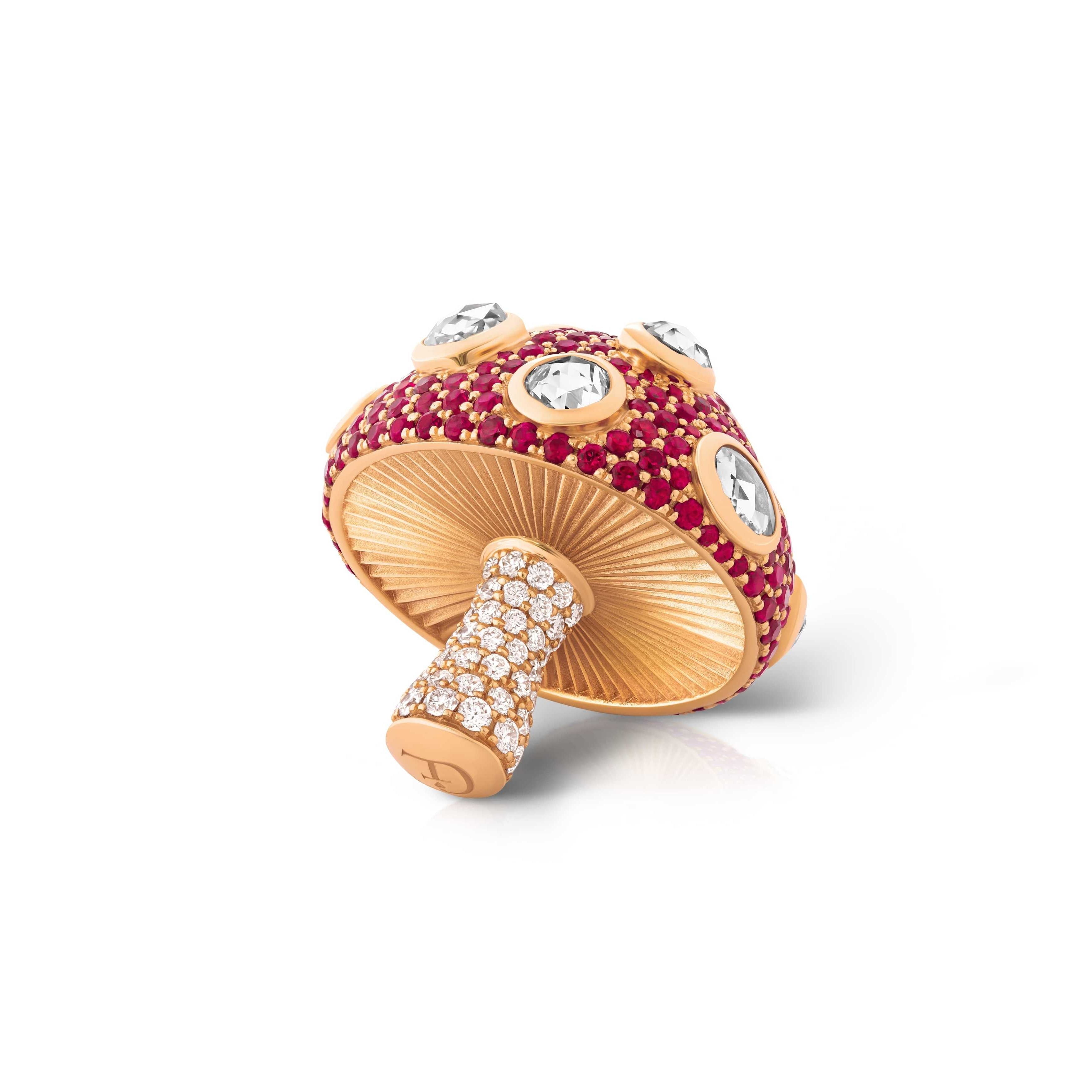 Mushroom-shaped jewelry piece with red gemstones and gold accents on a pendant