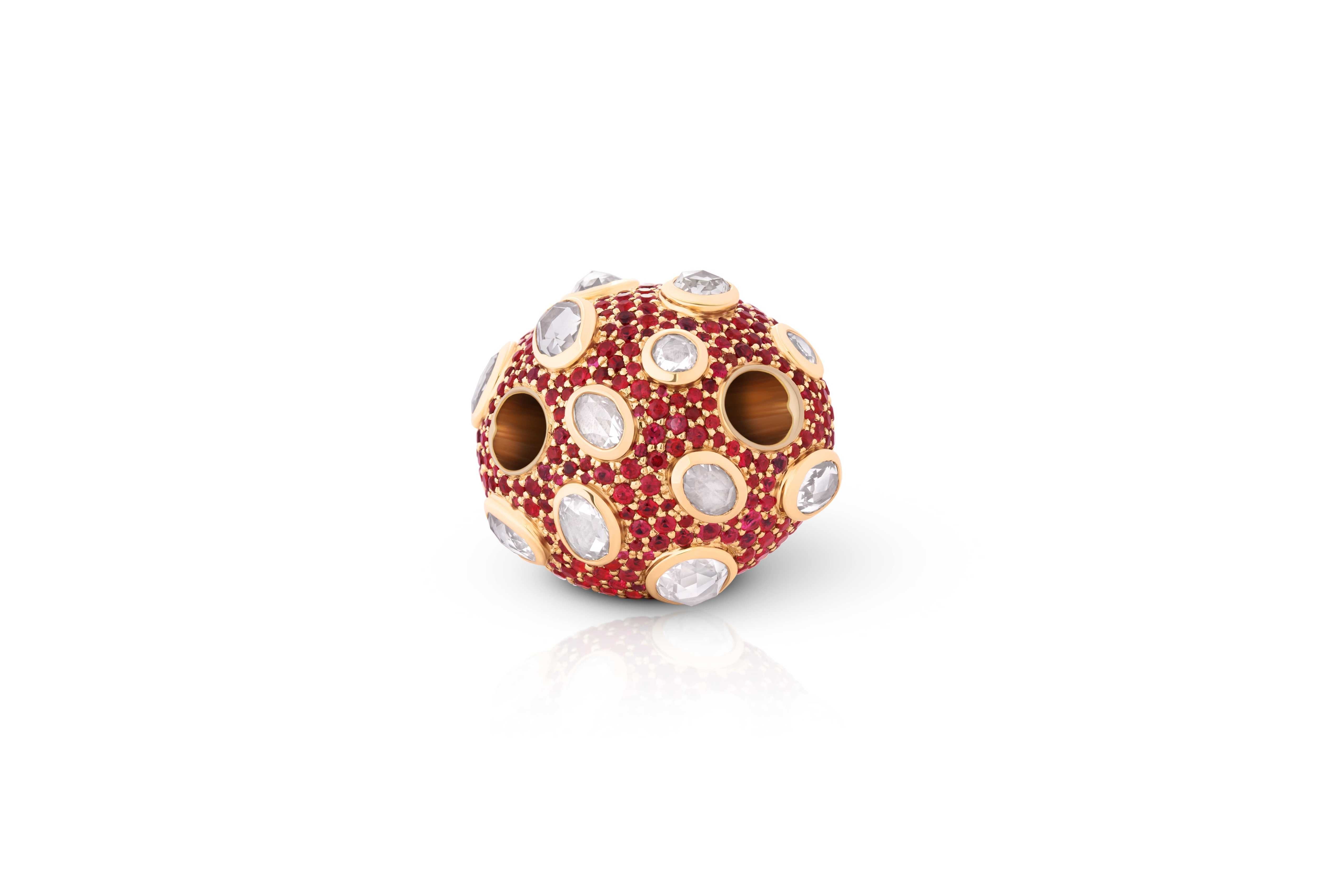 Mushroom-shaped jewelry piece with red gemstones and gold accents on a pendant