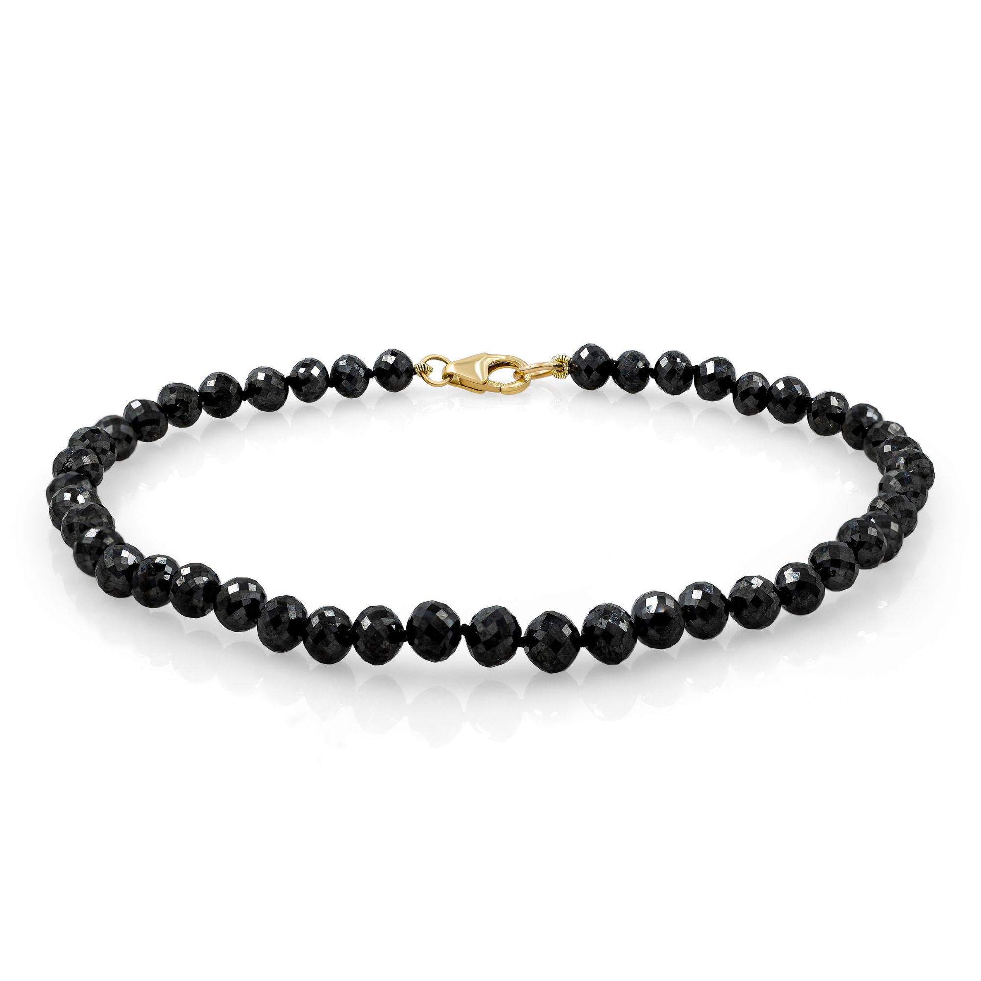 A black diamond bracelet with a gold clasp, showcasing the intricate chain link and the sparkling stones.
